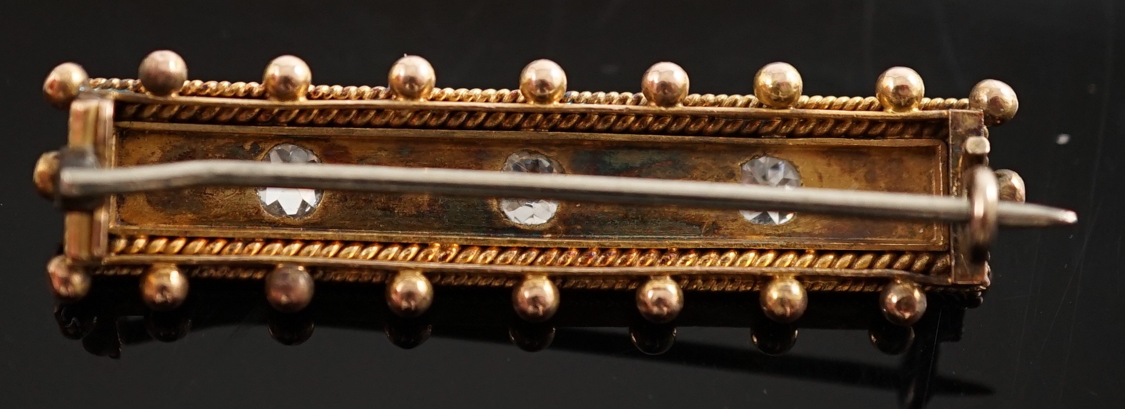 An early 20th century gold three stone diamond and four stone split pearl set bar brooch